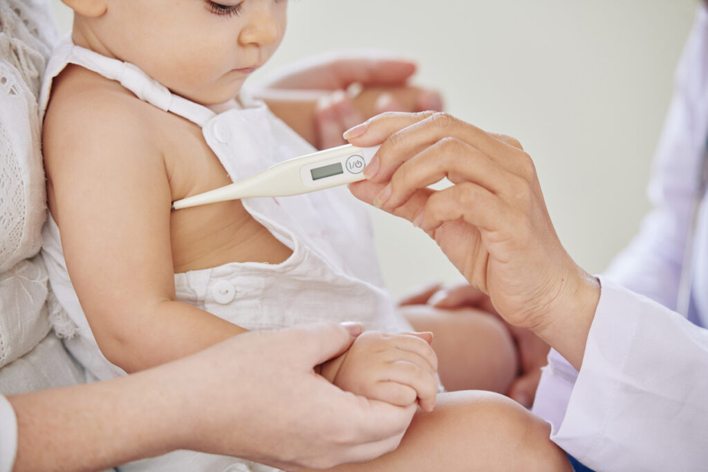 niña a la que le están tomando la temperatura para comprobar si tiene fiebre infantil